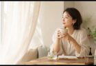 窓辺で温かい飲み物を持ちながら飲酒と女性の性機能を考える女性